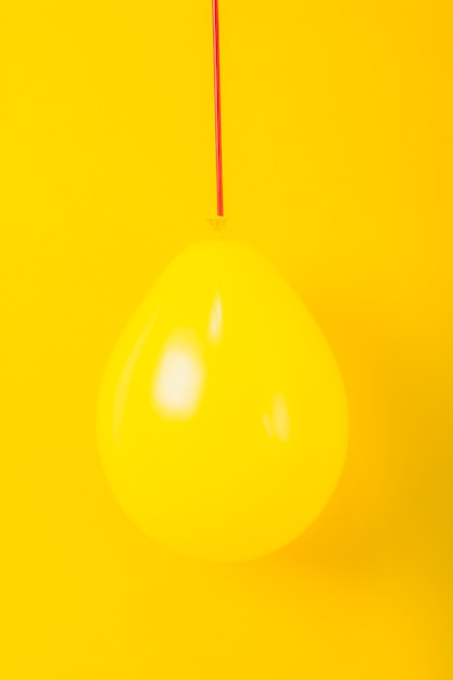 Free photo shiny balloon over the yellow background