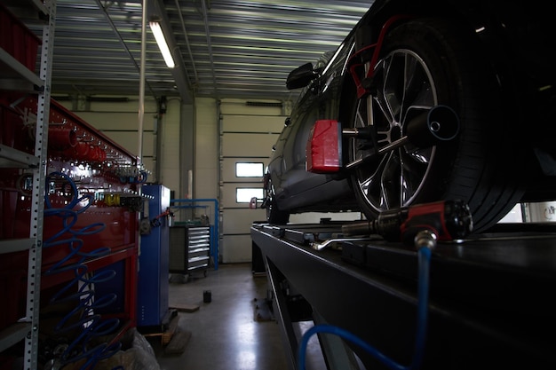 Free photo shiny new car at auto service got a problem with tyres, which will be sorted soon.