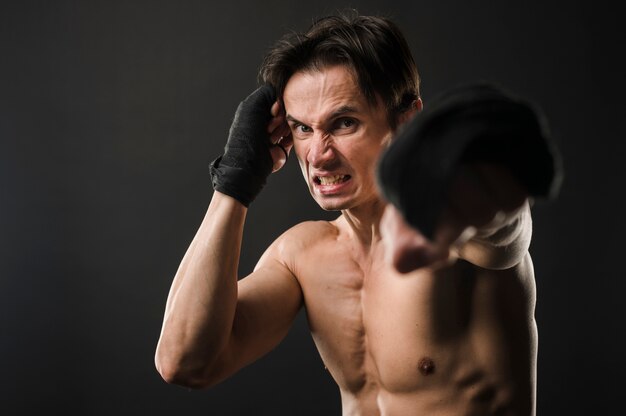 Shirtless athletic man in boxing gloves