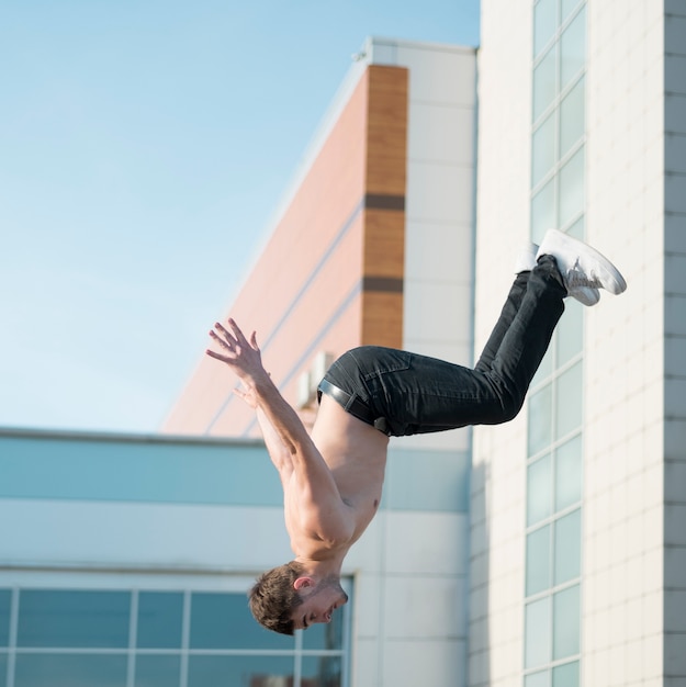 Free photo shirtless hip hop performer posing mid-air