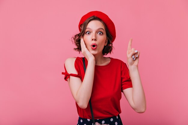 Shocked charming woman in elegant beret posing. Indoor portrait of attractive caucasian lady in french outfit.