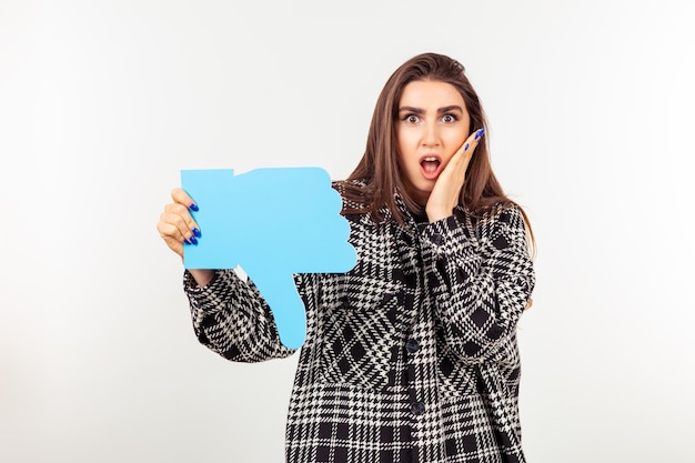 Shocked lady holding thumb down sign and stand on white background