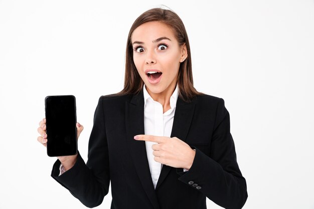 Shocked pretty businesswoman showing display of mobile phone