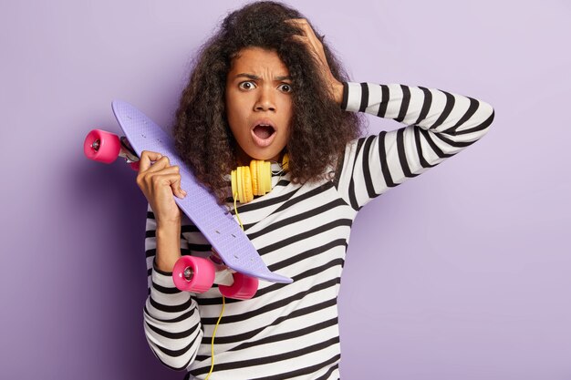 Shocked skater female posing with long board