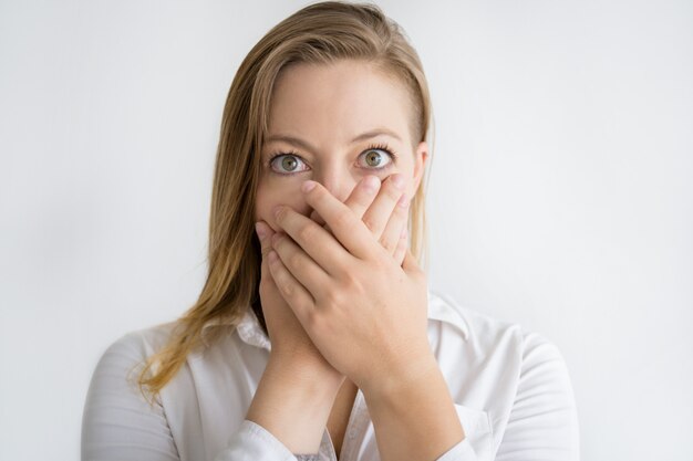 Shocked woman covering mouth with both hands