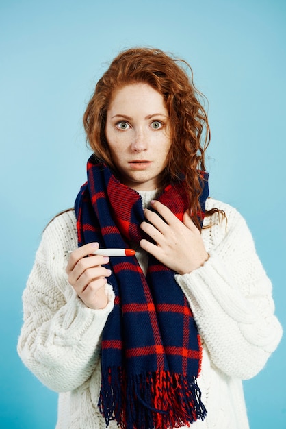 Free photo shocked woman with digital thermometer checking temperature at studio shot