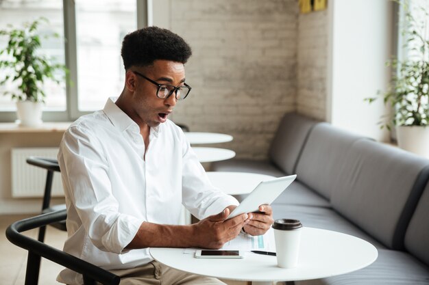 Shocked young african man sitting coworking