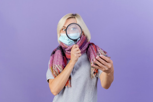 Shocked young blonde ill slavic woman wearing medical mask and scarf