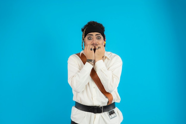 Free Photo shocked young guy holding his hands to his mouth and stand on blue background. high quality photo