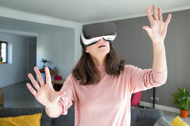 Shocked young woman learning world in virtual reality headset