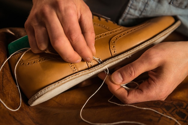 Free photo shoemaker in workshop making shoes