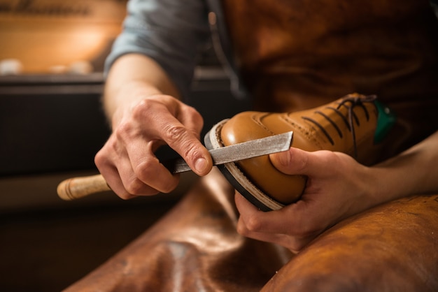 Shoemaker in workshop making shoes