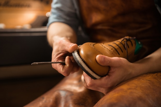 Free photo shoemaker in workshop making shoes