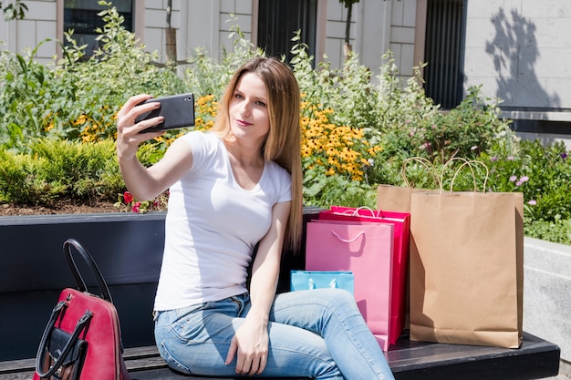 Shopaholic woman taking selfie on smartphone