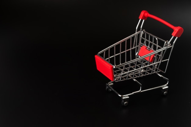 Free photo shopping cart on dark background with copy-space