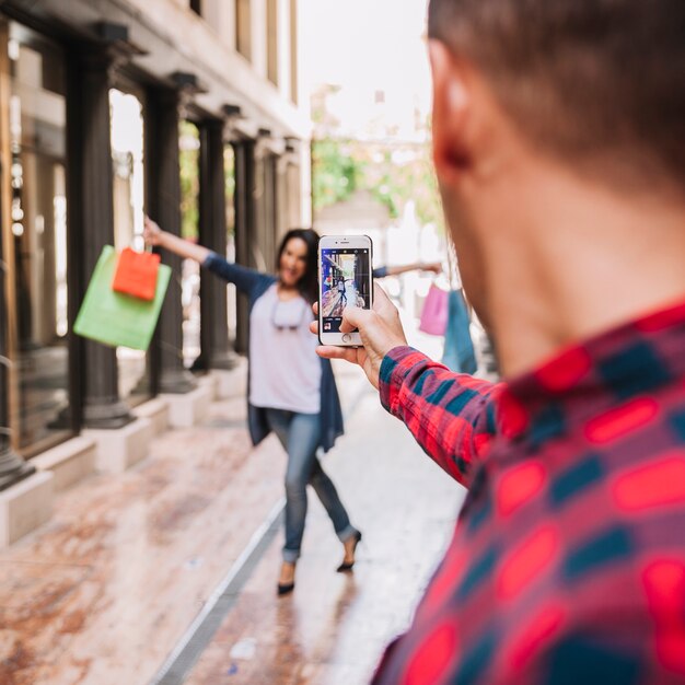 Shopping concept with boy taking photo of girlfriend