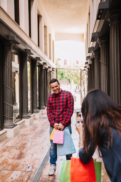 Shopping concept with girl taking photo of boyfriend