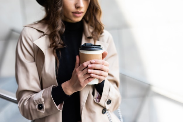 Shopping day. Coffee break. Attractive young woman with paper bags walking on city street.