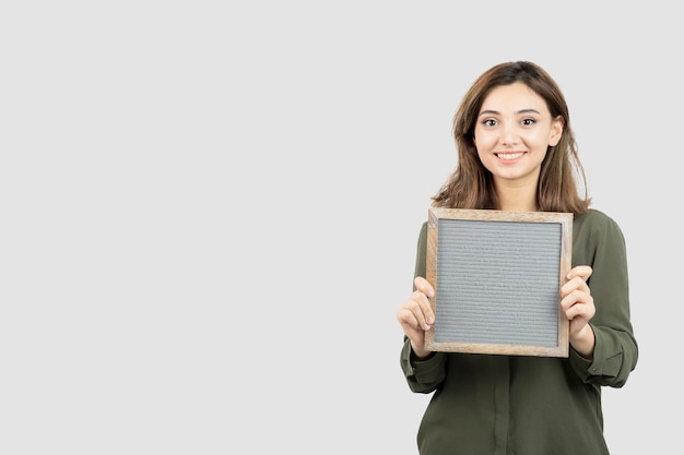 Shot of adorable young woman showing empty frame over white. High quality photo