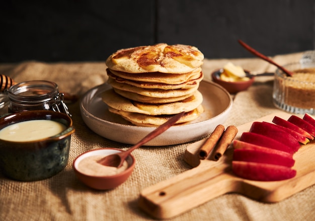 Shot of apple pancakes with apples and other ingredients on the table