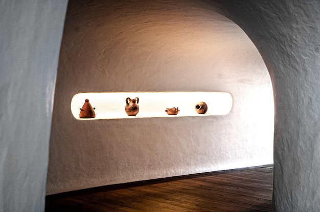 Free photo shot of a corridor with white walls and wooden floor with some ceramic jars and in lanzarote, spain