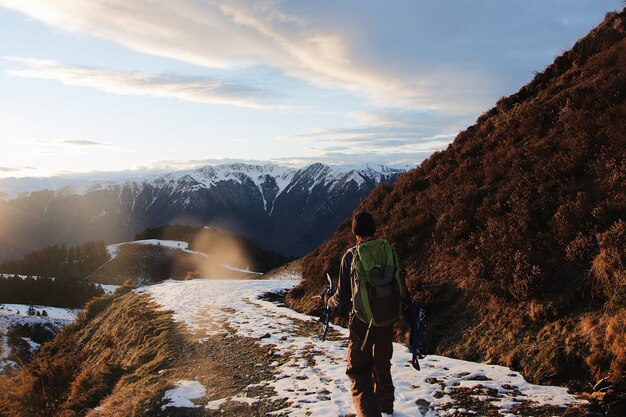 Behind shot of the hiker in the mountains covered in snow