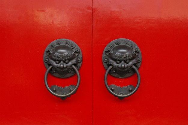 Free photo shot of an old chinese  styled metallic doorknobs with lion guardians