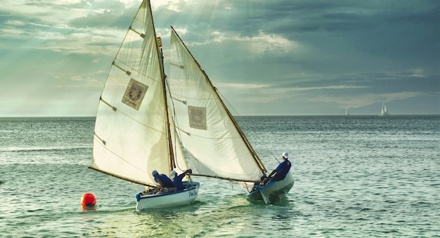 Free photo shot of people on the white boats swimming in the sea during cloudy weather