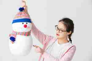 Free photo shot in the studio of the young asian woman holding a christmas snowman