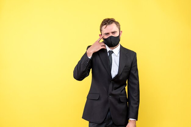 Shot of young man with confused facial expression while standing on the yellow