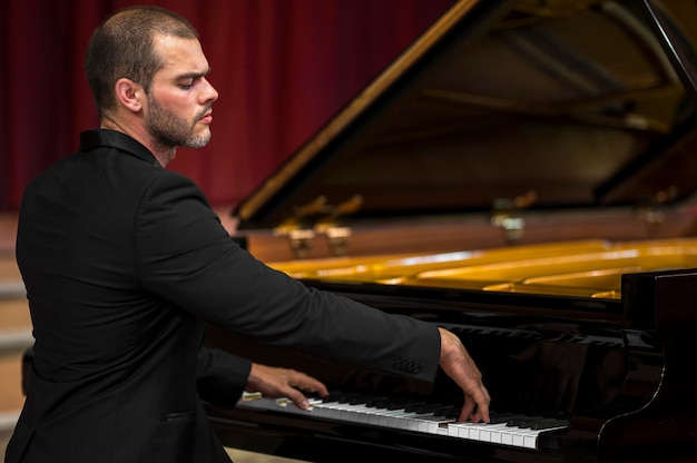 Over the shoulder view man playing piano