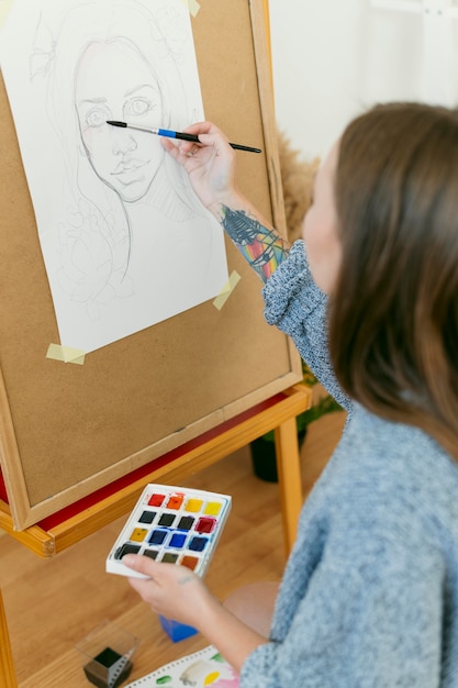 Over the shoulder view painter drawing a portrait