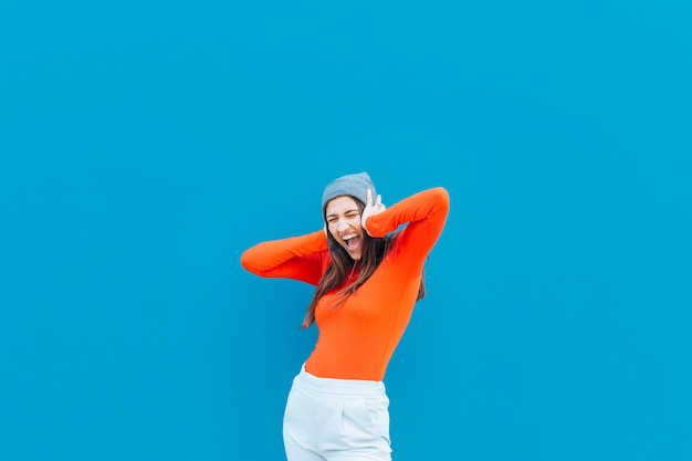 Free Photo shouting woman with her hands on ear wearing knit hat over blue background