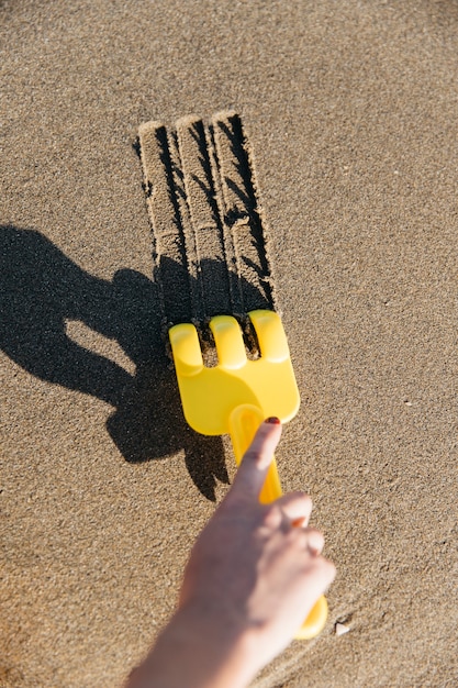 Free photo shovel drawing lines in the sand