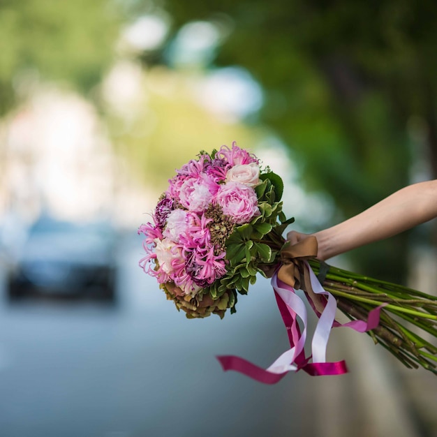 Free photo showing a purple bouquet of roses and floss flowers in the street view