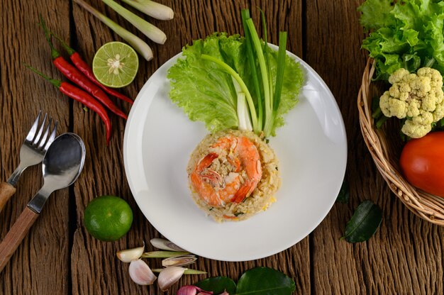 Shrimp fried rice on a white plate on a wooden table