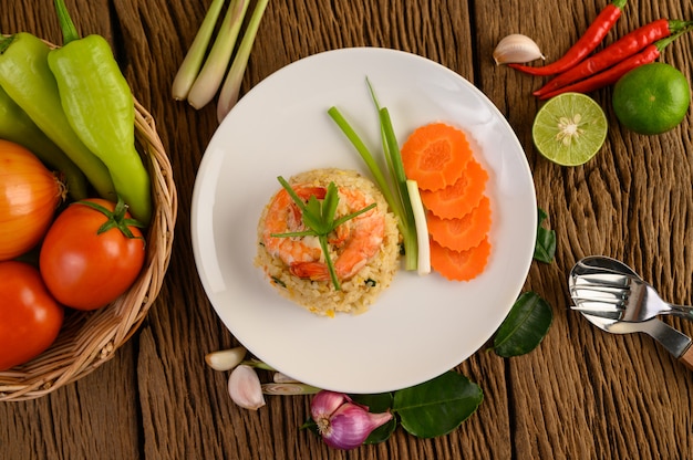 Shrimp fried rice on a white plate on a wooden table