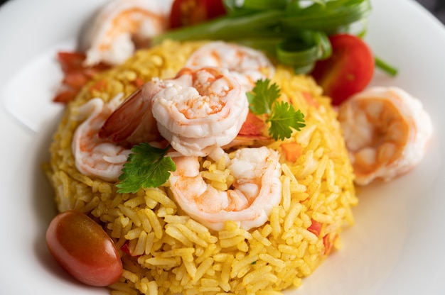 Shrimp fried rice with tomatoes, carrots and scallions on the plate