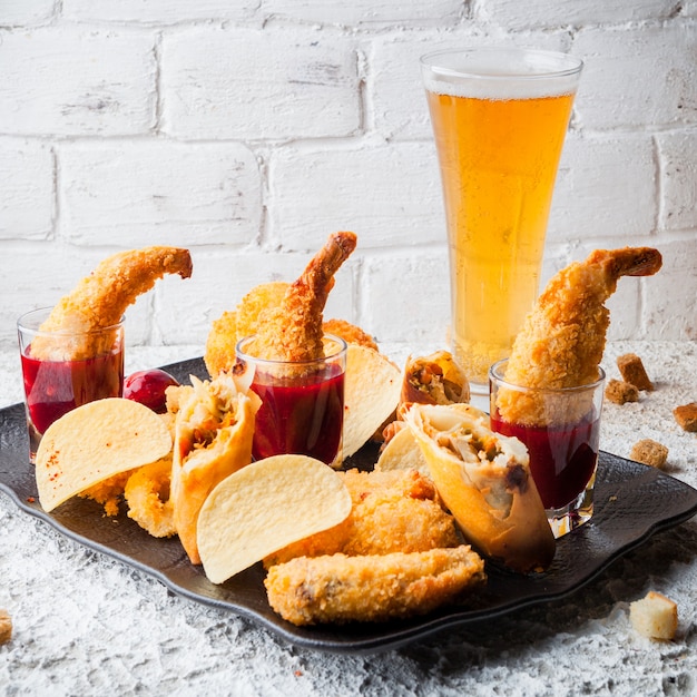 Free photo shrimps in batter with sauce and crisps and beer in plate