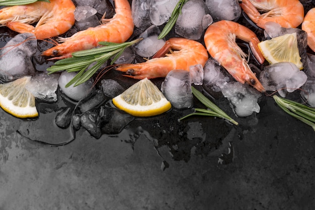 Free photo shrimps on ice with lemon and herbs