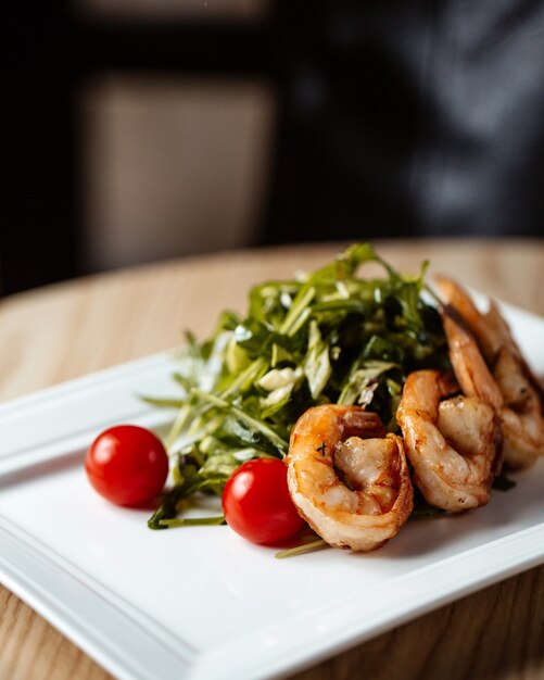 Shrimps served with arugula and tomatoes