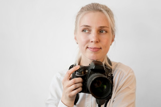 Free Photo shy cute girl holding a professional camera