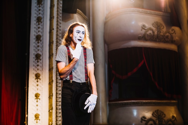 Free photo shy male mime artist standing on stage in the auditorium