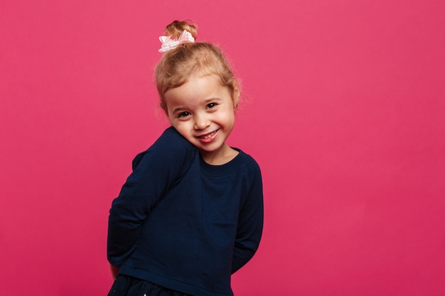 Free Photo shy young blonde girl posing  and looking at the camera over pink wall