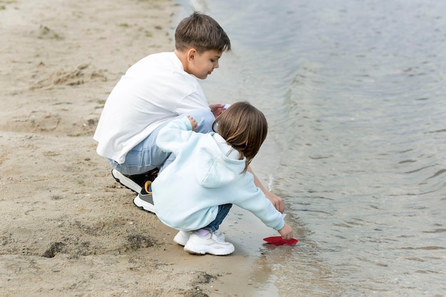 Siblings playing by the lake