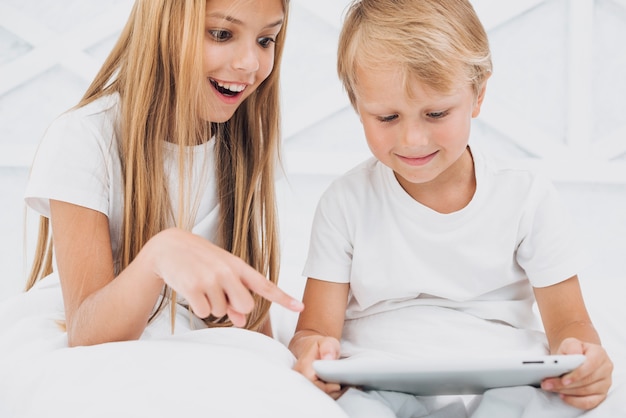 Siblings watching something funny on a tablet