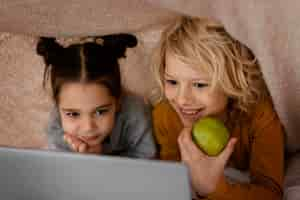 Free photo siblings watching video on laptop