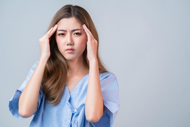 Sick asian female hand touch body head with bad feeling headache and stress in hospital uniform health and illness ideas concept