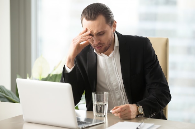 Sick businessman having severe headache