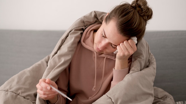 Free Photo sick female person wrapped in a blanket